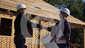Teamwork. concept building constructing architect slow motion video. two men builder in helmets shake hands contract