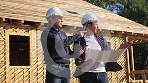 Teamwork. concept building constructing architect slow motion video. Two men builder in helmets study digital tablet the