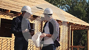 Teamwork. concept building constructing architect slow motion video. two men builder in helmets study the house plan