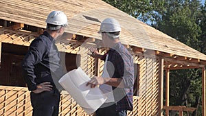 Teamwork. concept building constructing architect slow motion video. two men builder in helmets study the house plan