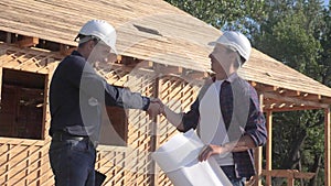 Teamwork. concept building constructing architect slow motion video. two men lifestyle builder in helmets shake hands