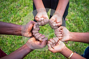 Teamwork concept with different skin color people touching their fists