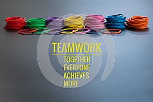 Teamwork concept. group of colorful rubber band on black background with word Teamwork, Together, Everyone, Achieves and More