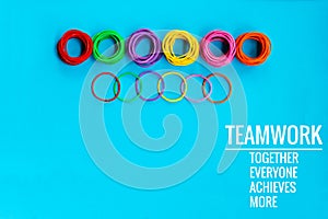 Teamwork concept. group of colorful rubber band on blue background with word Teamwork, Together, Everyone, Achieves and More