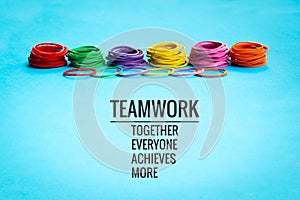 Teamwork concept. group of colorful rubber band on blue background with word Teamwork, Together, Everyone, Achieves and More photo