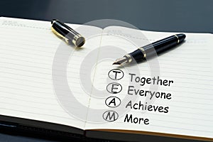 Teamwork concept. luxury pen writing word Teamwork, Together, Everyone, Achieves and More on the daily notebook