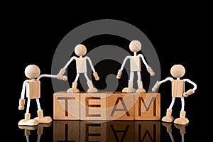 Teamwork concept, Wood cube block with word â€œTEAMâ€ and Wooden Stick Figures team.