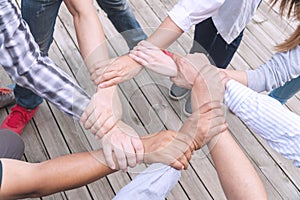 Teamwork connection success concept. people holding hands circle together in the park. Human hands agreement join team