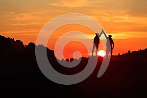 Teamwork couple celebrating in inspiring mountains sunset