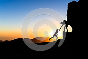 Teamwork couple climbing helping hand