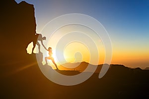 Teamwork couple climbing helping hand photo