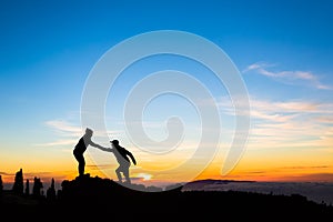 Teamwork couple climbing helping hand