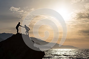 Teamwork couple climbing hiking with helping hand