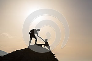 Teamwork couple helping hand trust in inspiring mountains photo