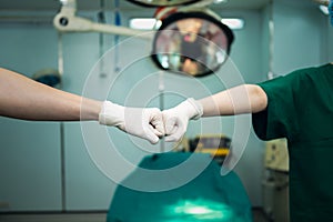 teamwork of doctors are using hand for fist bump to show synergy treatment the patient