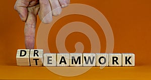 Teamwork and dream work symbol. Businessman turns wooden cubes and changes the word `dreamwork` to `teamwork`. Beautiful orang photo