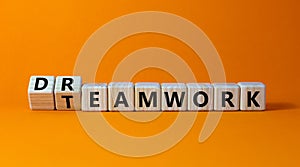 Teamwork and dream work symbol. Turned wooden cubes and changed the word `dreamwork` to `teamwork`. Beautiful orange backgroun photo