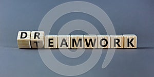Teamwork and dream work symbol. Turned wooden cubes and changed the word `dreamwork` to `teamwork`. Beautiful grey table, grey photo
