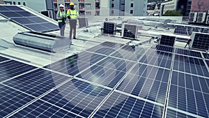Teamwork, drone and solar engineers on roof, planning and people outdoor in city. Technician, photovoltaic panels and
