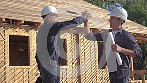 Teamwork handshake. concept building constructing architect slow motion video. two men builder in helmets shake hands