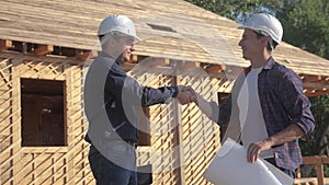 Teamwork handshake. concept building constructing architect slow motion video. two men builder in helmets shake hands