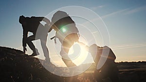 Teamwork help business three men hold hand travel silhouette concept. Group of tourists lends a helping hand climb the