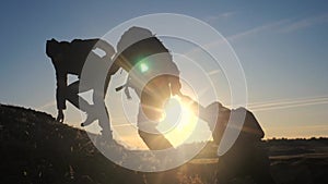 Teamwork help business three men hold hand travel silhouette concept. group of tourists lends a helping hand climb the