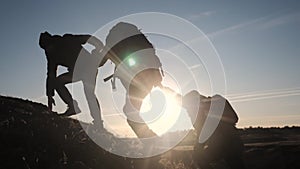 Teamwork help business three men hold hand travel silhouette concept. group of tourists lends a helping hand climb the