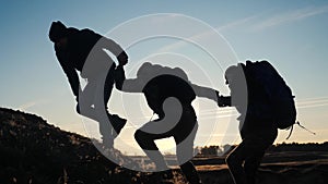 Teamwork help business three men hold hand travel silhouette concept. group of tourists lends a helping hand climb the