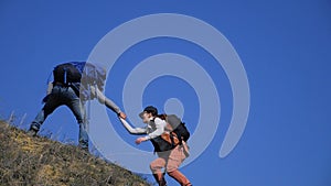 Teamwork help business travel concept couple man and woman. of tourists lends a helping hand lifestyle climb the cliffs