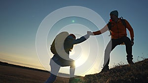 teamwork. help business travel silhouette concept. group team of tourists lends helping hand climb the cliffs mountains