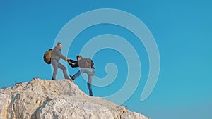 Teamwork help business travel silhouette concept. group of tourists lends a helping hand climb the cliffs mountains