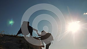 teamwork help business travel silhouette slow motion video concept. top helping hand silhouette between two climbers