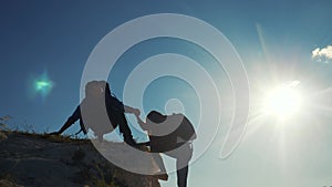 Teamwork help business travel silhouette slow motion video top concept. Helping hand silhouette between two climbers