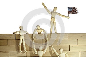 Teamwork or Illegal immigrants climbing a USA border wall