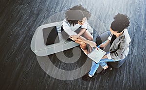 Teamwork improves the quality of your work. High angle shot of two businesswomen working together on a digital tablet in