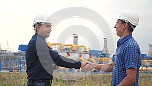 Teamwork. industry gas production station concept. Slow motion video. Two engineers in helmets are studying working with