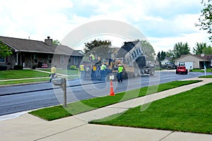 Teamwork laying fresh hot rolled blacktop