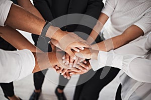 Teamwork leads to many victories. Closeup shot of a group of unrecognisable businesspeople joining their hands together