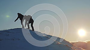 Teamwork lifestyle business travel concept. two hikers gives hand winter snow tourists climbers climb to the top of the