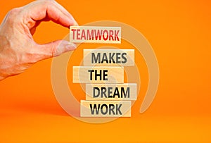 Teamwork makes dream work symbol. Concept words Teamwork makes the dream work on wooden blocks on beautiful orange background.