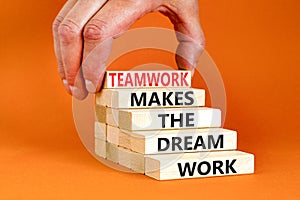 Teamwork makes dream work symbol. Concept words Teamwork makes the dream work on wooden blocks on beautiful orange background.