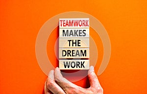 Teamwork makes dream work symbol. Concept words Teamwork makes the dream work on wooden blocks on beautiful orange background.