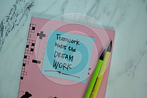 Teamwork Makes The Dream Work write on sticky note isolated on Wooden Table. Motivation concept photo