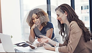 Teamwork makes good business great business. two businesswomen using a digital tablet together during a collaboration at