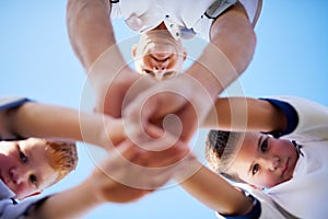 Teamwork makes us all winners. Low angle shot of two young soccerplayers and their coach in a huddle.