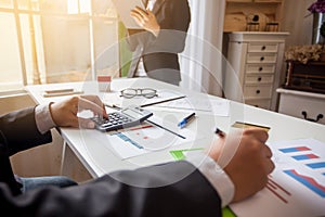 Teamwork process, Business team using a calculator to calculate and documents on  desk