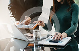 Teamwork process, Business team using a calculator to calculate the numbers of statistic business profits growth rate on documents