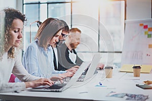 Teamwork process concept.Young coworkers work with new startup project at sunny office.Horizontal, blurred background.