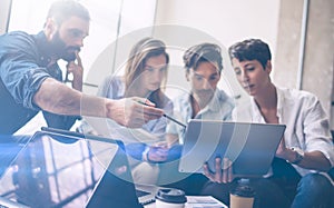 Teamwork process.Young coworkers work with new startup project in office.Woman holding touch pad in hands,bearded man